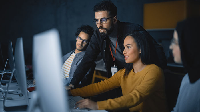 Data scientists viewing computer screen.